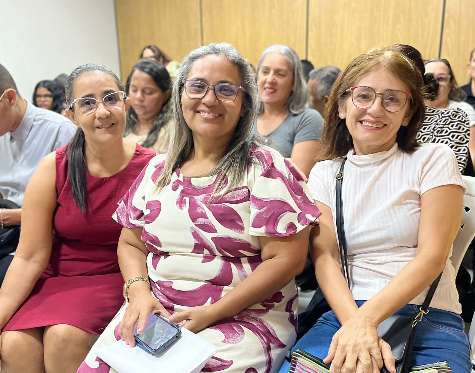 tres mulhers sentadas em uma sala de seleção